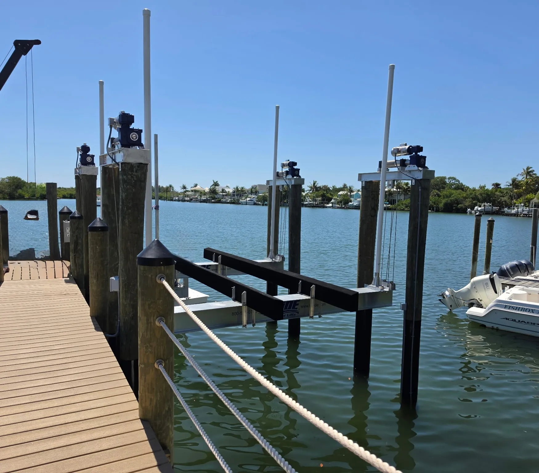 Row of boat lifts on new pilings along a composite dock built by Florida Marine Builders